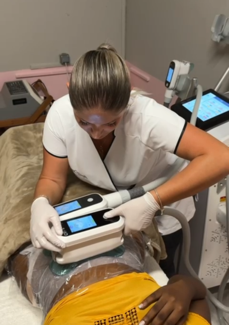 Traitement esthétique sur le corps, praticienne utilisant un appareil de cryolipolyse.